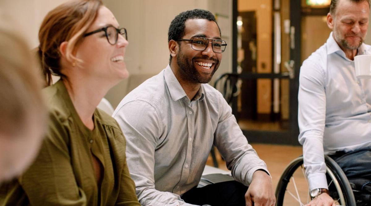 Colleagues sitting around a table laughing 